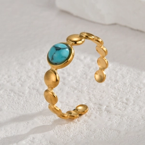 Elegant gold bead open ring featuring a round turquoise gemstone on a white textured stone
