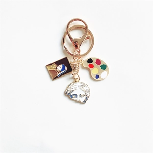Artistic gold keychain featuring Girl with a Pearl Earring, palette and Venus charms