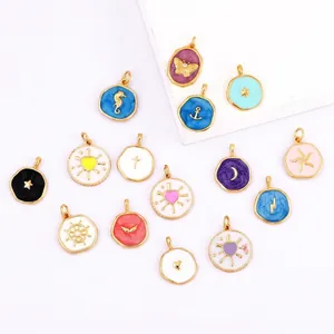 Flat lay of colorful enamel charms in butterfly and moon shapes on white pedestals