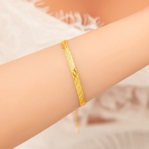 Close-up of 18k gold plated stainless steel herringbone snake chain on female wrist