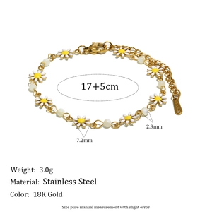 Detailed view of 18K gold-plated stainless steel bracelet with white enamel daisies and beads