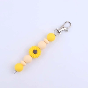 Detail of sunflower silicone bead keychain with yellow petals and silver metal lobster clasp