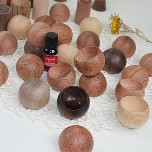 Vue macro de boules et bols diffuseurs en bois naturel sur un tissu en maille blanche