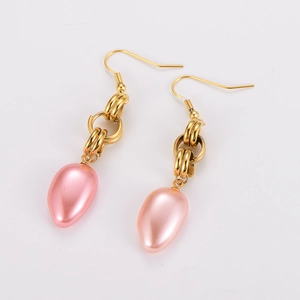 Dettaglio di eleganti orecchini in acciaio inossidabile dorato con perle rosa pendenti