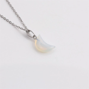 Détail d'une chaîne argentée avec pendentif lune en pierre d'opale blanche