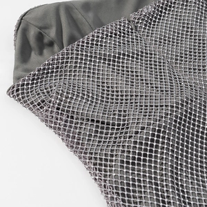 Détail de tissu en maille grise avec strass et paillettes sur une mini robe