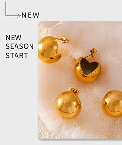 Macro shot of minimalist gold spherical earrings with a polished mirror finish detail