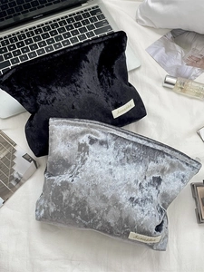 Velvet cosmetic bags in black and silver grey shown in an elegant lifestyle setting