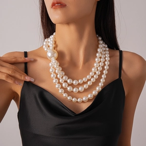 Detailed close-up of a triple-layer faux pearl necklace with an oversized pearl accent