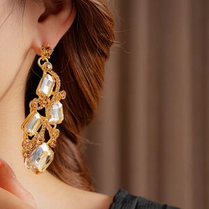 Detailed close-up of vintage gold square earrings with inlaid champagne rhinestones
