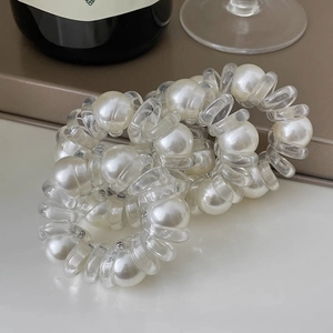 Détail de perles blanches et d'élastiques spirales transparents en ensemble pour femmes