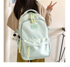 Detail of mint green school backpack with cute panda plush charm and brand leather patch