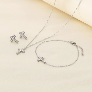 Detailed view of silver cross jewelry set with cubic zirconia stones and stainless steel