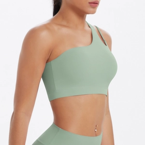 Close-up of sage green asymmetrical one-shoulder sports bra with matte elastic fabric