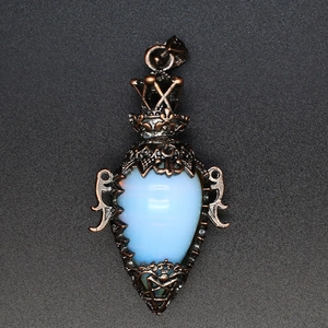 Close-up of vintage bronze crown pendant with drop-shaped opal and star engraving