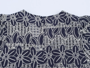Detail der marineblauen Blumenstickerei und verdecktem Reißverschluss hinten am Kleid