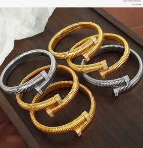 Detail of gold and silver nail-shaped spiral bangles with pavé sparkling crystals