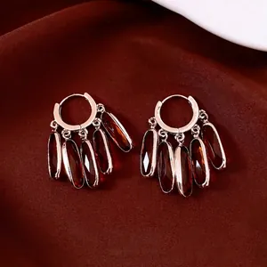 Vintage gold hoop earrings with amber glass oval fringe pendants on dark velvet background