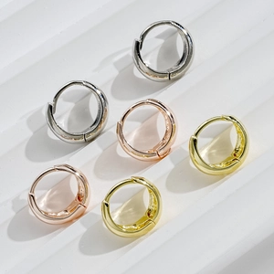 Macro detail of geometric C-shaped hoop earring set in silver, gold, and rose gold finish
