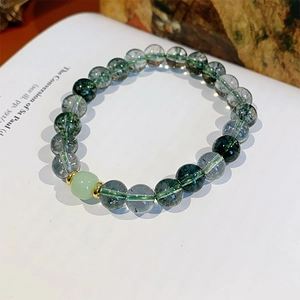 Detailed macro of green phantom quartz and tiger eye beads on an open book background