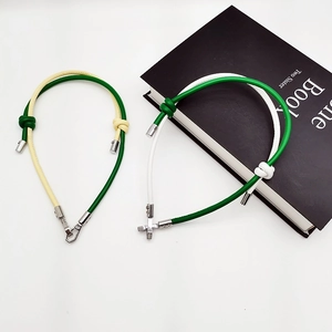 Detail of hand-woven leather lanyards in yellow-green and white-green with T-bar clasps