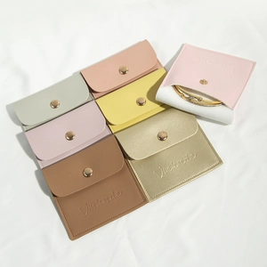 Detailed macro view of colorful PU leather jewelry pouches with snap buttons and logo