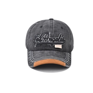Detail of Los Angeles embroidery on vintage washed grey baseball cap with brown suede brim