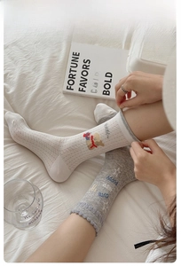 Close-up of gray cotton mesh socks with star pattern and elegant agaric lace cuffs