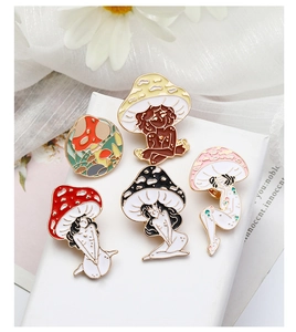 Detailed view of mushroom girl enamel pins set on elegant gift box with floral decor