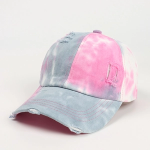 Close-up of tie-dye baseball cap with distressed torn edges and pastel marble patterns