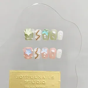 Handgefertigte kurze Press-On-Nägel mit grünen, rosa und perlweißen Stern-Anhängern
