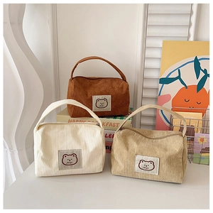 Detailed view of three corduroy cosmetic bags featuring cute bear embroidery patches