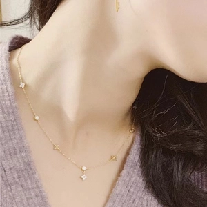 Elegante collar de trébol en plata de ley bañada en oro de 18K con diamantes en una modelo