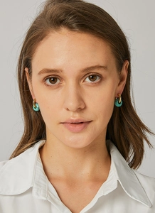 Close-up of vintage gold hoop earrings featuring turquoise marble textured sphere beads