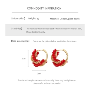 Detail view of red glass beaded hoop earrings showing 20mm size and copper material specs