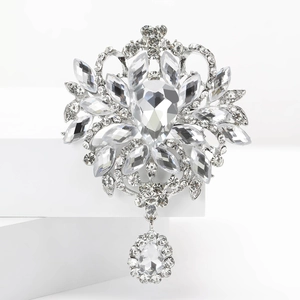 Macro d'une broche florale argentée en strass avec un pendentif étincelant en forme de poire