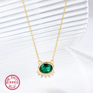 Detail of 925 sterling silver necklace with green oval gemstone and clear crystals