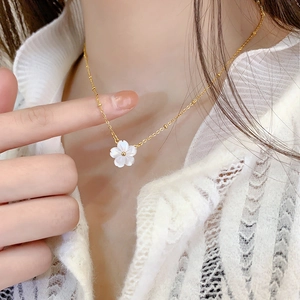 Elegant white shell flower pendant necklace in gold titanium steel on a female model