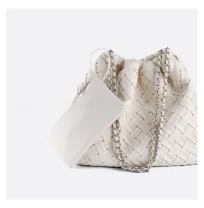 Detail of woven white leather tote bag with silver chain strap and matching coin purse