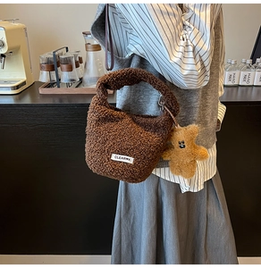 Détail d'un sac seau en polaire marron avec charm ours en peluche et étiquette logo