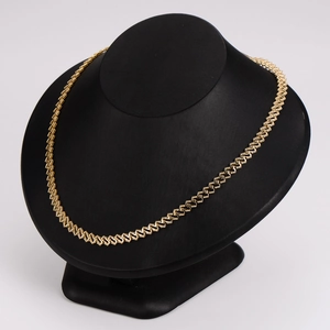 Gold minimalist stainless steel feet pendant necklace on a black display stand