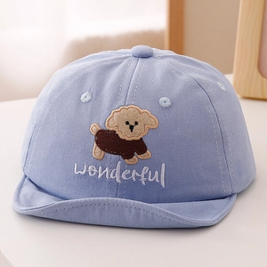 Détail d'une casquette bleue pour bébé avec broderie chiot et lettrage wonderful