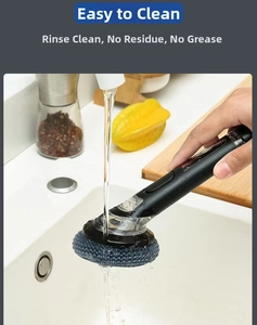 Gros plan d'une brosse de cuisine à long manche rincée à l'eau pour un nettoyage facile