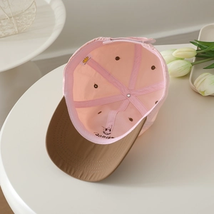Detailed interior view of a pink kids' baseball cap showing stitch work and woven label