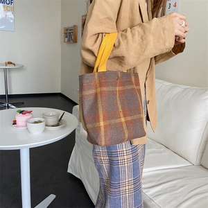 Detail of retro plaid wool lunch bag with yellow handles and vintage bronze snap closure