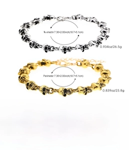 Dettaglio di bracciali punk teschio in lega con finiture argento vintage e oro