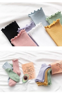 Detail of macaron color knitted socks featuring elegant ruffled edges and vertical ribbed texture