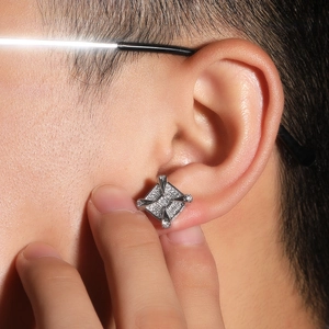 Close-up of a silver dragon claw stud earring with square zircon on a male model
