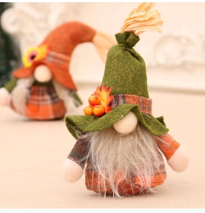 Close-up of autumn gnome dolls with maple leaves and berries in warm forest colors