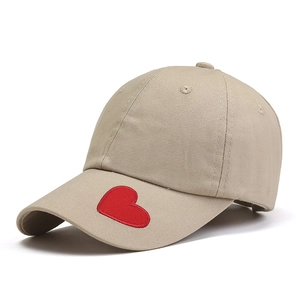 Beige baseball cap with red heart embroidery on the brim, minimalist cotton design